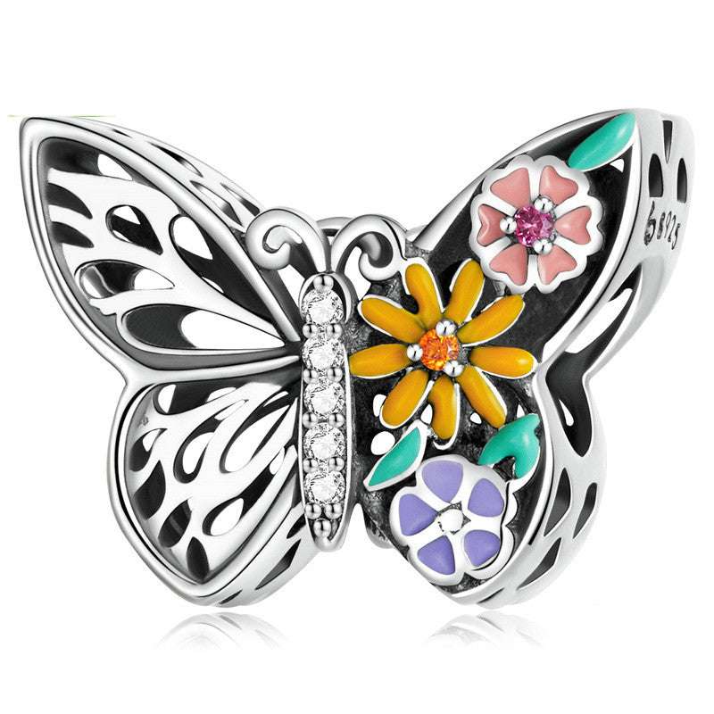 Colourful Charms butterfly charm with enamel flowers and crystal accents. Add a pop of color to your jewelry with this unique design.