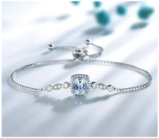 Silver bracelet with a clear gemstone on a light background