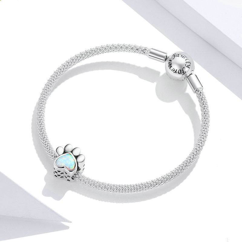 Adorable dog paw charm attached to a silver mesh bracelet, perfect gift for pet lovers and charm enthusiasts.