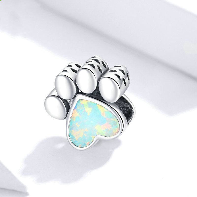Silver dog paw charm with colorful opal heart detail, a playful accessory for pet lovers' charm bracelets.