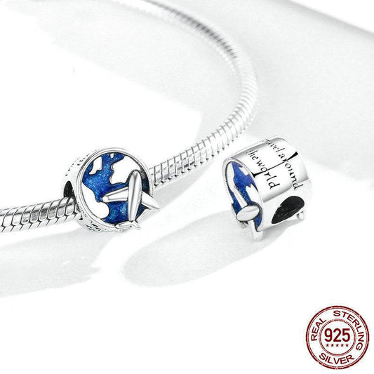 Sterling silver Travel Charm with an airplane and globe design, shown on a charm bracelet. Ideal for enhancing your journey with luck and style.