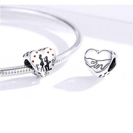 Heart-shaped Elegant Engagement Charm on a bracelet, showcasing romantic couple silhouette and red hearts, ideal for commemorating special moments.