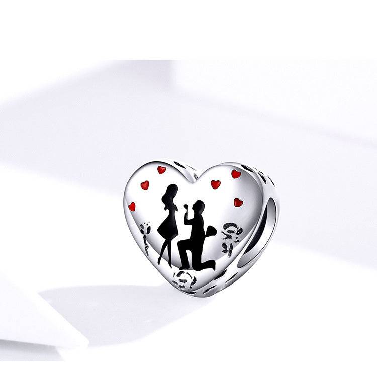 Close-up of Elegant Engagement Charm with a kneeling proposal design and red heart details, crafted for meaningful bracelet customization.