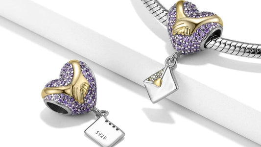 Sterling silver Love Letter Charm with purple stones and gold-tone hands, shown on a bracelet and separately to highlight its romantic design.