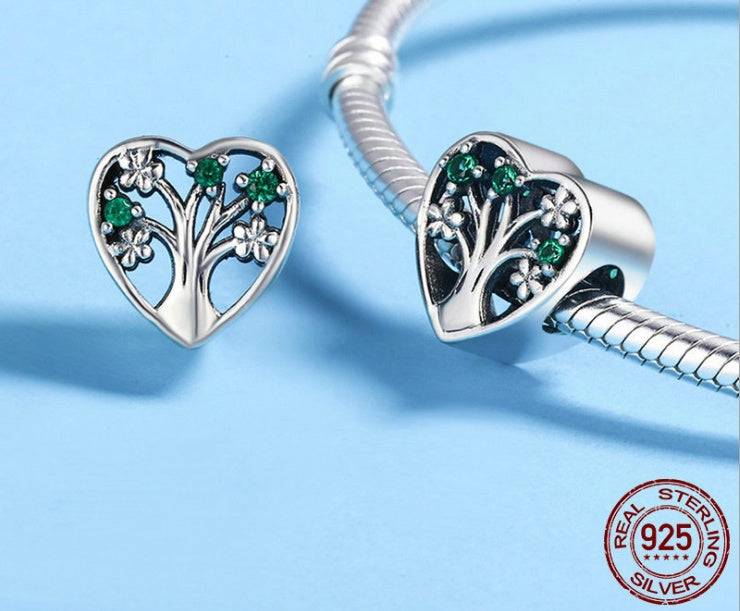 Heart Tree of Life Charm with green stones and floral design, displayed with bracelet to showcase its symbolic beauty and craftsmanship.