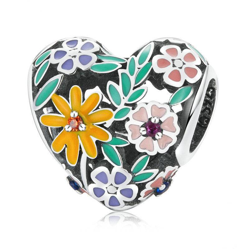 Heart-shaped Colourful Charms charm adorned with multicolored enamel flowers. Showcase your unique style with this vibrant accessory.