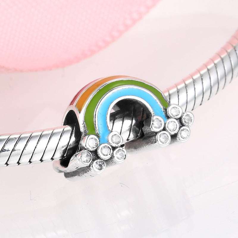 Close-up of Vibrant Rainbow Charm with orange, green, and blue enamel on sterling silver. Ideal for bracelets or necklaces to express unique style.