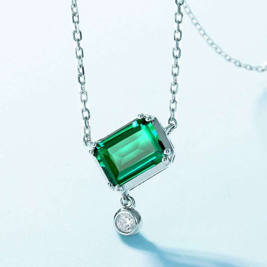 Close-up of Rectangular Emerald Necklace showcasing 1.36ct green emerald in 925 silver pendant with a dangling diamond accent.