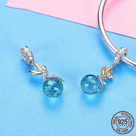 Pair of Blue Crystal Fairy Charms displayed on a silver bracelet, featuring a sparkling blue gemstone and sterling silver fairy with gold-tone wings.
