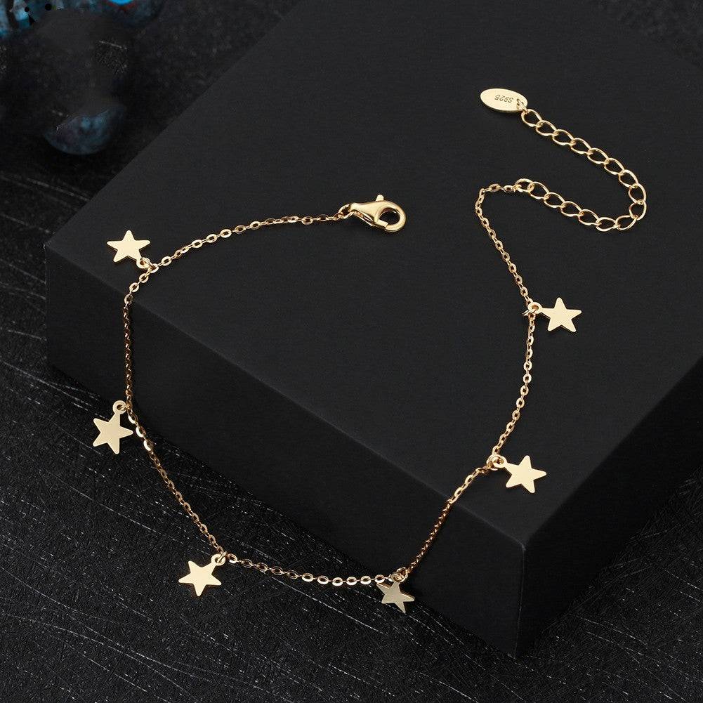 Gold anklet with dangling star charms from the Stunning Stars Anklet line, adding celestial elegance to any jewelry collection.
