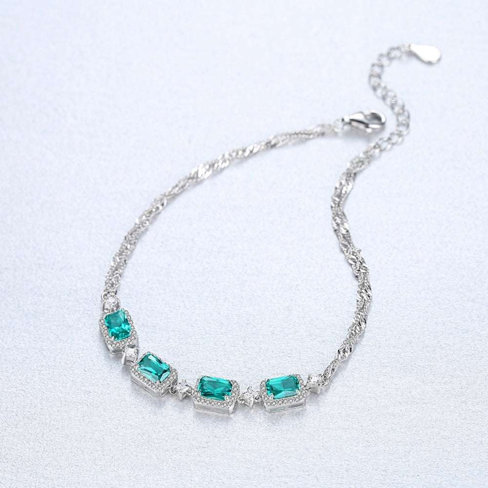 Top view of Emerald Bracelet - Baguette Cut Emerald with intricately designed silver chain and vivid green stones for stylish occasions.