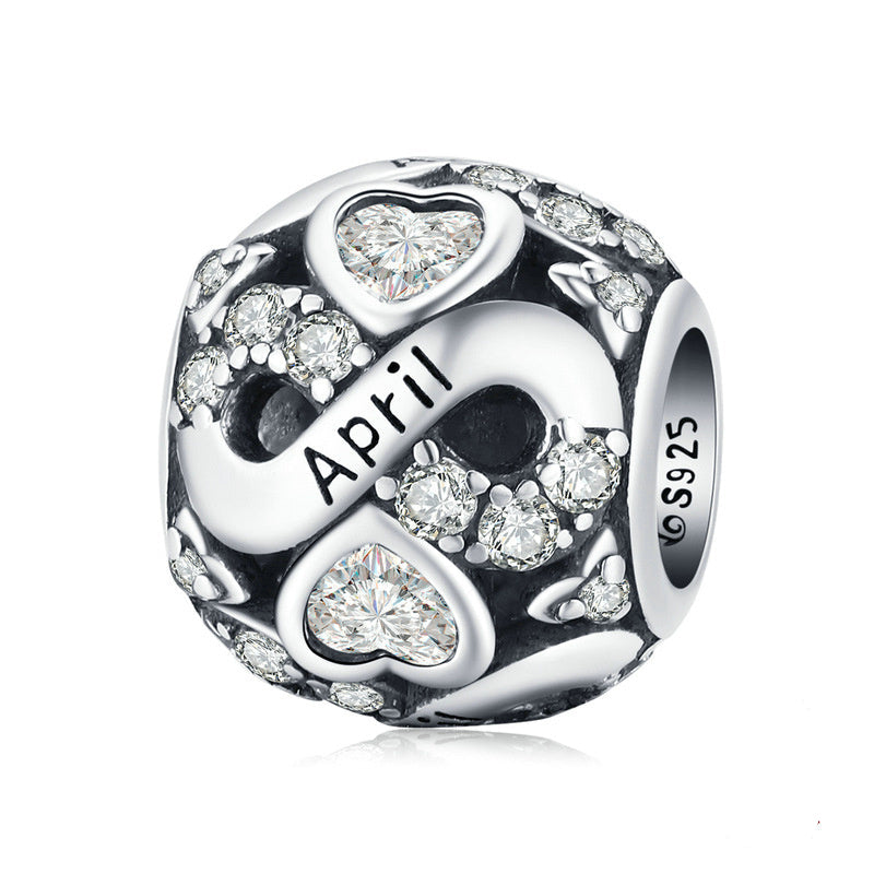 Silver charm with 'April' and heart designs on a white background