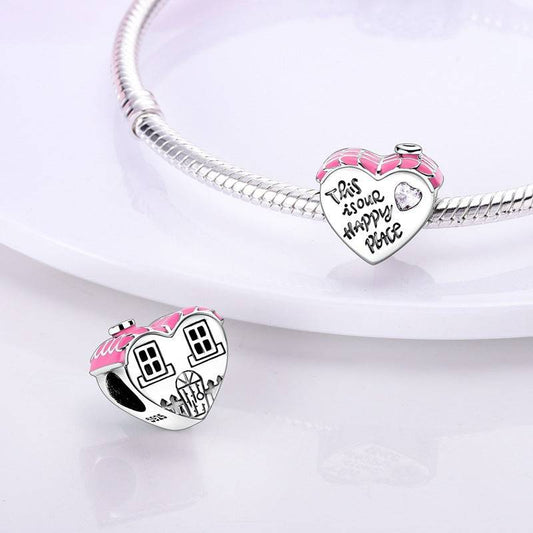 Heart-shaped charm with pink roof and engraved 'This is our happy place' text. Ideal love charm for bracelets to express warmth and affection.