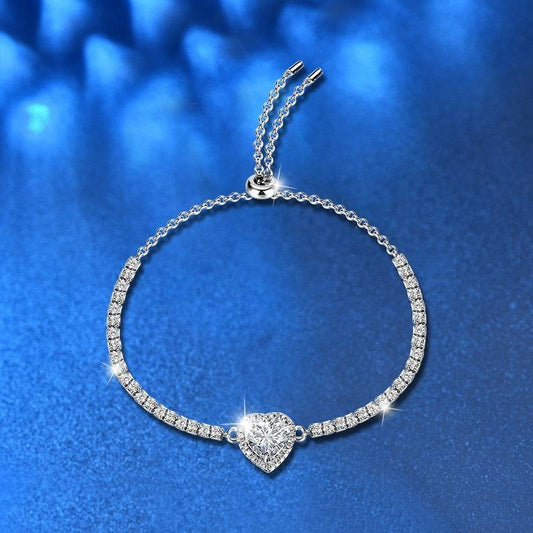 Elegant Silver Moissanite Heart Bracelet with sparkling moissanite stones on a silver chain, showcased against a blue background.