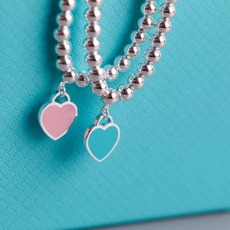 Silver heart tag bracelets with pink and turquoise enamel charms, perfect elegant gift for fashion-forward individuals.