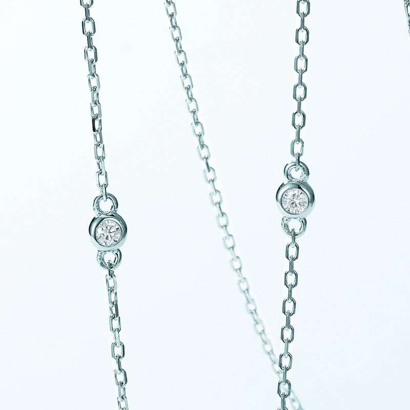 Detail of silver cross chain from Emerald Necklace - Rectangular Design, featuring bezel-set round diamonds for added elegance.