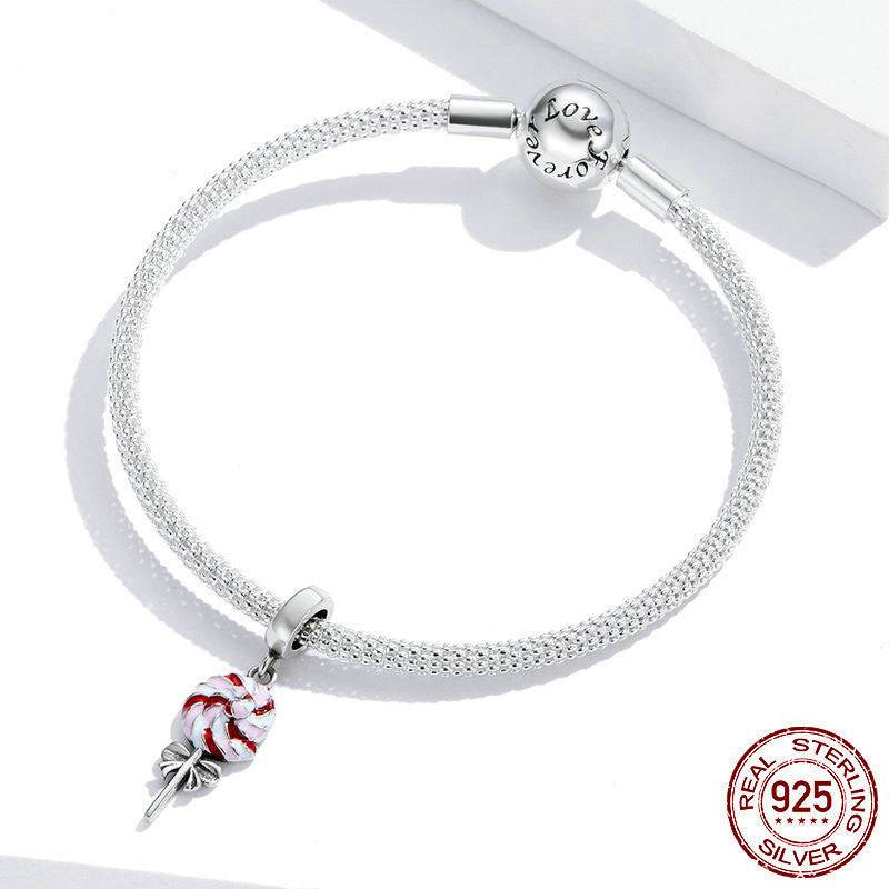 Sterling silver bracelet with attached Lollipop Charm for Bracelets, showcasing a whimsical red and white candy design.