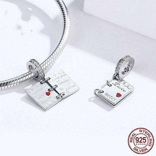 Sterling silver Romantic Love Notes Charm for Bracelets shown with and without bracelet, featuring heartfelt engravings and red heart detail.