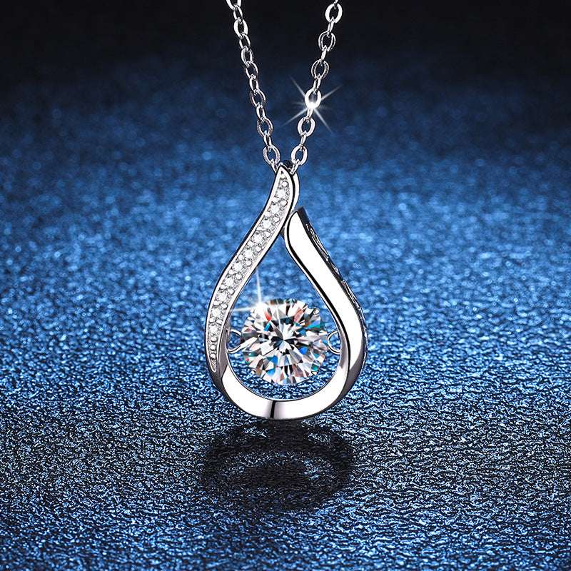 Close-up of Droplet Moissanite Necklace on blue background, featuring sparkling 1-carat moissanite in a silver electroplated teardrop frame.