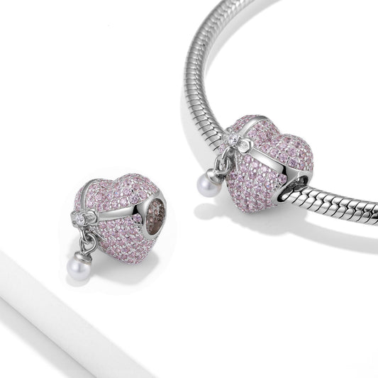 Pearl Pink Bow Charm displayed on a silver bracelet, showcasing its sparkling pink stones and elegant pearl drop.
