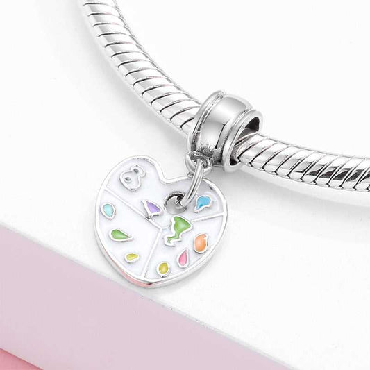 Art Palette Charm attached to a silver bracelet, showcasing its vibrant enamel colors and artistic design for jewelry collections.