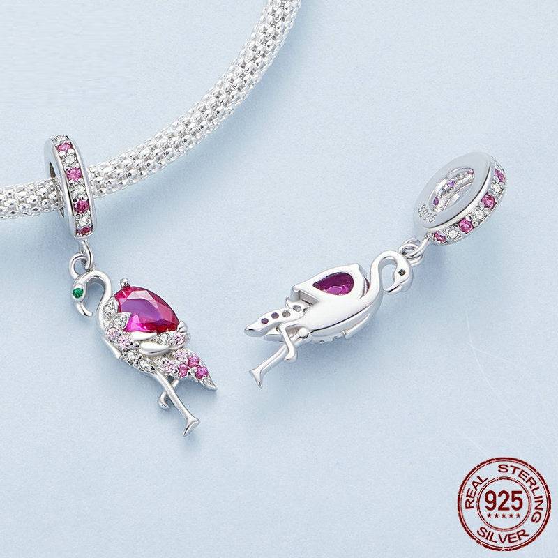 Close-up of two adorable cute flamingo charms for bracelets, made from 925 sterling silver with pink and white crystals.