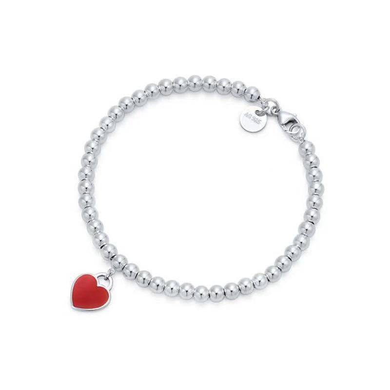 Elegant silver heart tag bracelet with red enamel charm and beaded design, ideal personalised gift for stylish everyday wear.