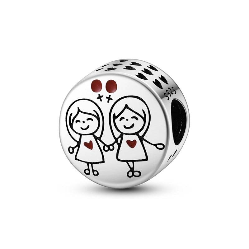 Round charm with two girls holding hands and red heart details. A sweet love charm for bracelets celebrating sisterhood or friendship.