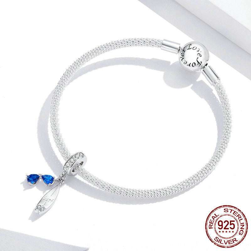 Sterling silver bracelet featuring the Surfboard Charm with blue sunglasses, perfect for beach lovers seeking a stylish accessory.