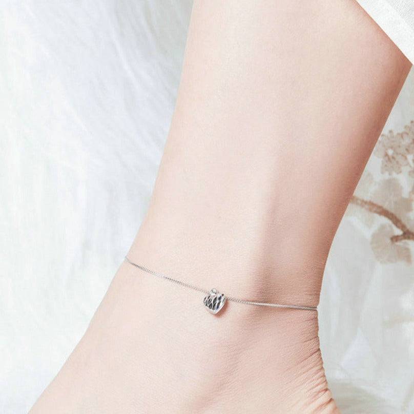 Charming Dangle Heart Anklet worn on ankle, showcasing its delicate chain and heart pendant. A stylish jewelry piece for everyday elegance.