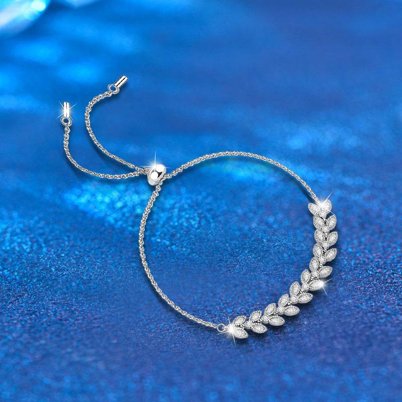 Moissanite Petal Bracelet - Silver Wheat Moissanite design with adjustable sterling silver chain on a shimmering blue background. Elegant leaf motif for jewelry lovers.
