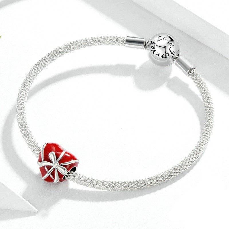 Elegant Bow Heart Charm in red enamel with silver bow detail on a silver bracelet, symbolizing love and grace for romantic jewelry collections.