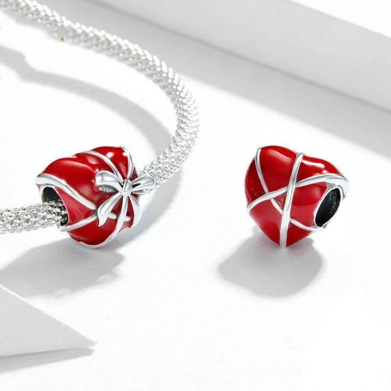 Elegant Bow Heart Charm in red enamel with silver bow detailing, perfect for bracelets. A romantic jewelry piece symbolizing love and grace.