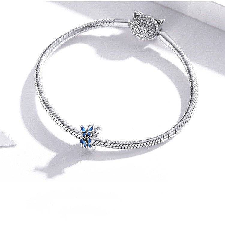 Charming Butterfly Spacer with blue enamel wings on a silver bracelet, perfect for enhancing elegance in jewelry collections.