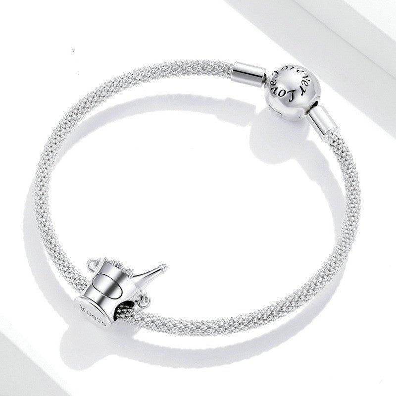 Champagne Bucket Charm on a silver bracelet with 'Love' engraved clasp, ideal for festive and elegant jewelry collections.