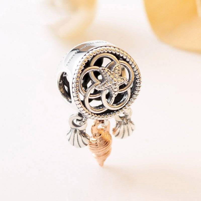 Dreamcatcher Charm - Capture Your Dreams & Wishes 🌙✨ featuring intricate silver detailing with dangling shell accents and a rose gold seashell pendant.