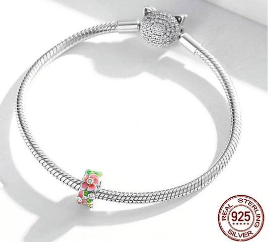 Elegant Floral Spacer charm on sterling silver bracelet, featuring pink and green enamel flowers. Perfect for nature-inspired jewelry styling.