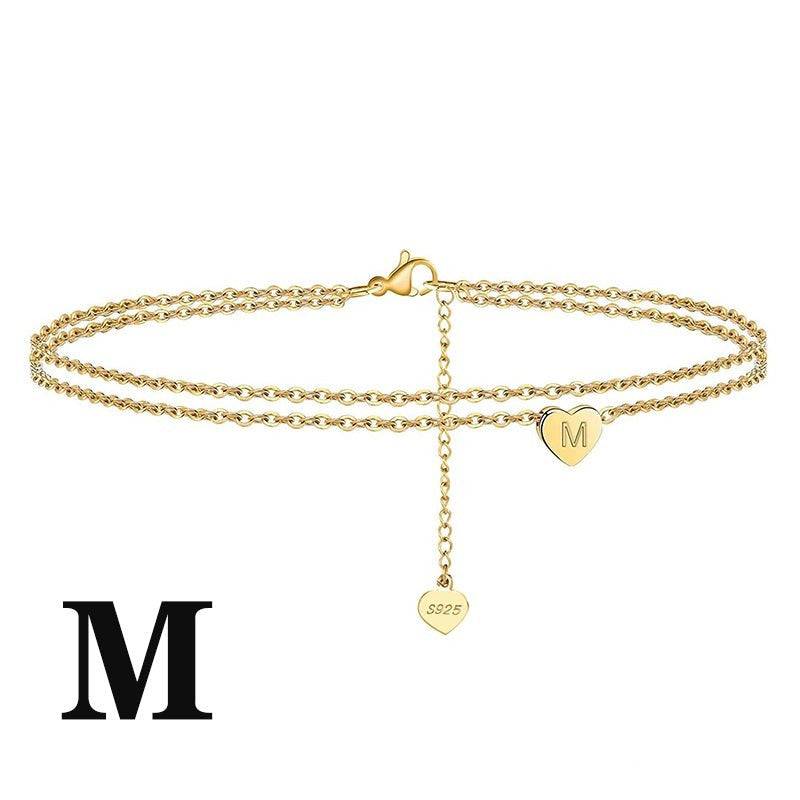Letter Heart Anklet with 'M' engraved charm in gold finish. Stylish and meaningful jewelry for gifting or daily wear.