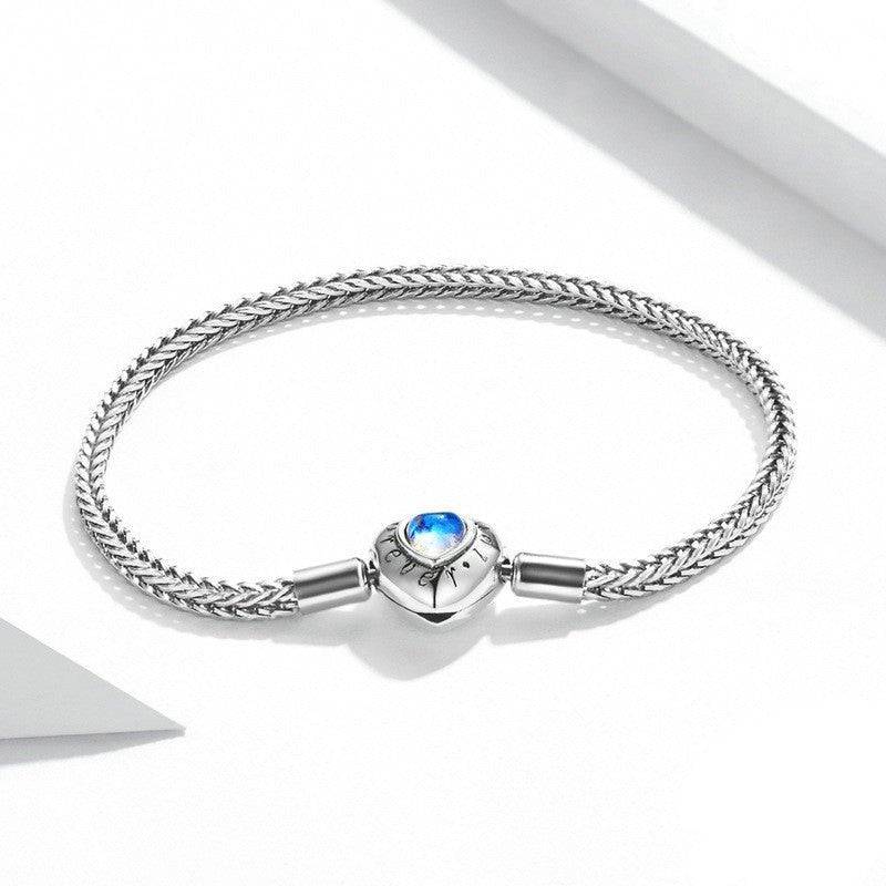 Heart Moonstone Inlaid Sterling Silver Bracelet featuring a woven chain and glowing heart-shaped moonstone centerpiece. Elegant & unique jewelry gift.