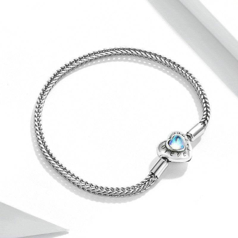 Close-up of Heart Moonstone Inlaid Sterling Silver Bracelet with intricate braided chain and luminous heart moonstone. Stylish accessory for women.