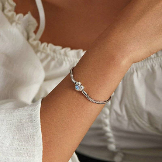 Elegant Heart Moonstone Inlaid Sterling Silver Bracelet worn on wrist, showcasing its delicate design and radiant moonstone charm. Perfect for any occasion.