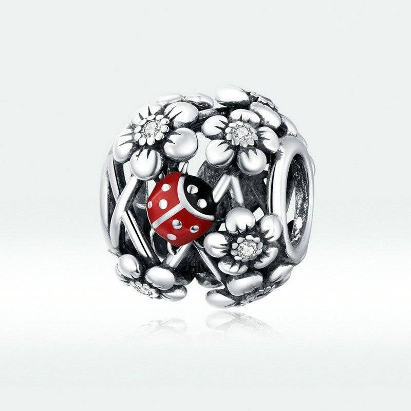 Ladybird Lucky Charm featuring a red ladybird nestled among silver floral accents. Durable and versatile charm for bracelets or pendants.