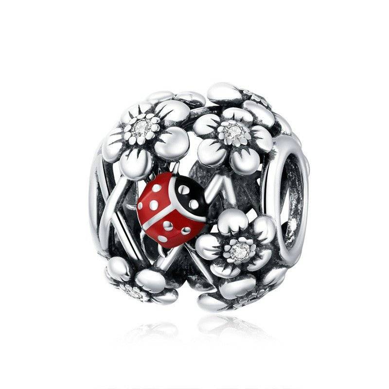 Ladybird Lucky Charm - Good Fortune Symbol features a red enamel ladybird nestled among silver floral accents. Durable charm for bracelets or pendants.