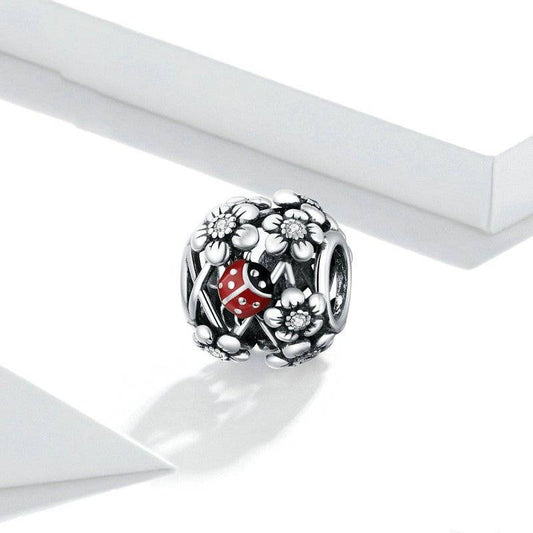 Ladybird Lucky Charm - Good Fortune Symbol featuring a red ladybird among detailed silver flowers. Durable and versatile for charm bracelets.