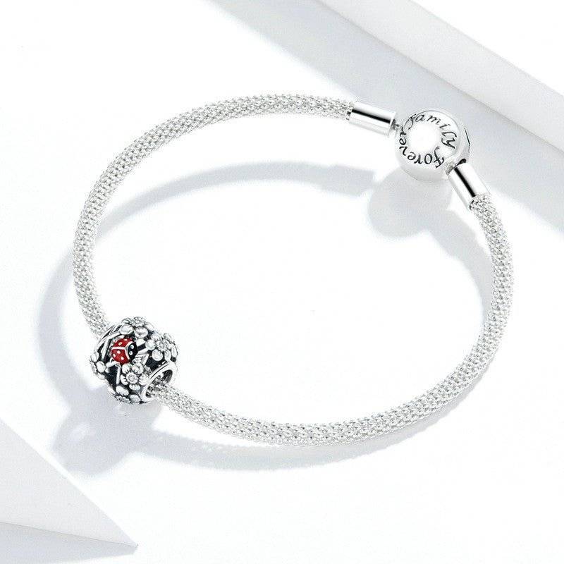Ladybird Lucky Charm - Good Fortune Symbol on silver mesh bracelet, featuring detailed red and black ladybird design for versatile jewelry styling.