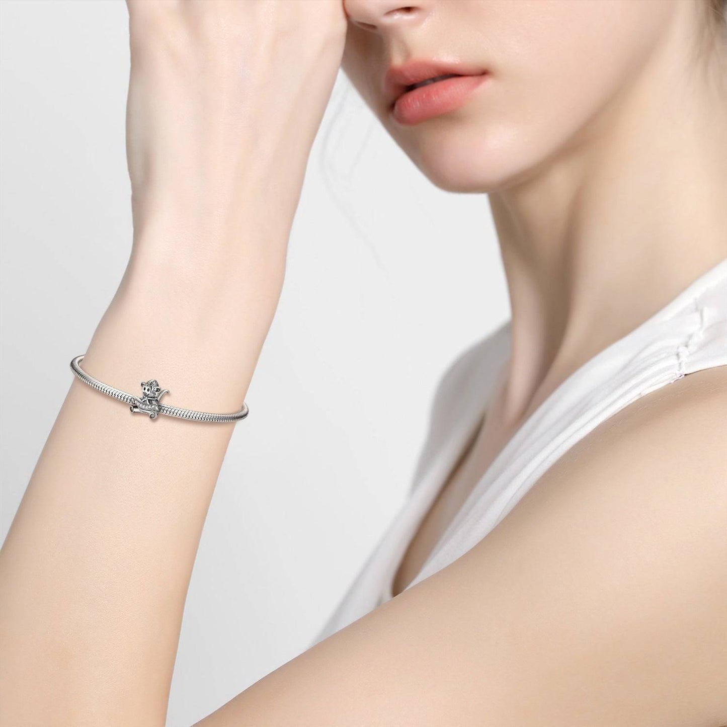 Playful Monkey Charm on silver bracelet worn by woman, adding fun and character to jewelry. Ideal for charm collectors and animal lovers.