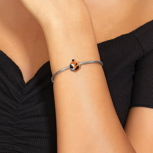 Nightmare Before Christmas charm worn on a silver bracelet, showcasing its spooky pumpkin and Jack Skellington design on a woman's wrist.