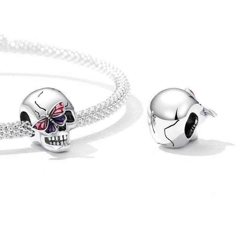 Vintage-inspired Retro Skull Charm on a silver bracelet, showcasing detailed skull design with butterfly accent for bold fashion statements.