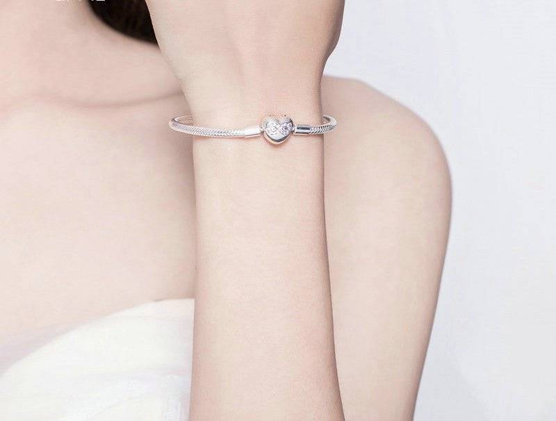 Model wearing the Snake Bone Bracelet, showcasing its sleek silver finish and heart clasp for a bold fashion statement.