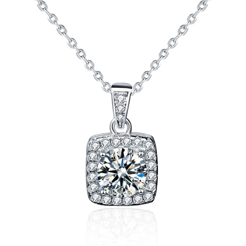 This is a beautiful silver necklace featuring a cushion-shaped pendant adorned with a central round-cut diamond surrounded by a halo of smaller diamonds. 